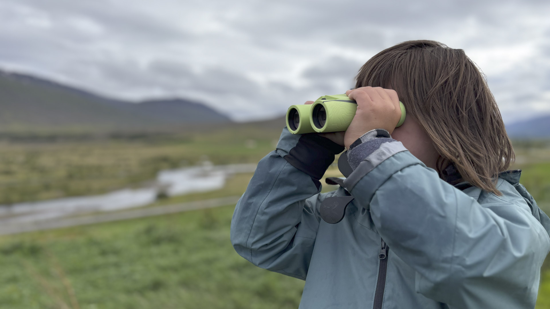 Un binocolo nelle mani di un giovane favorisce la scoperta della natura e costituisce un invito alla fruizione responsabile dell'ambiente